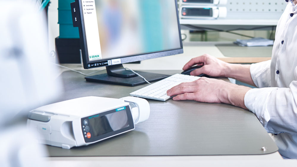 Somebody is sitting in front of a PC - there is also a space pump on the desk