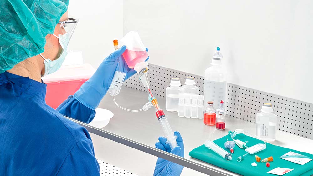 Female pharmacist draws up syringe under lamina airflow