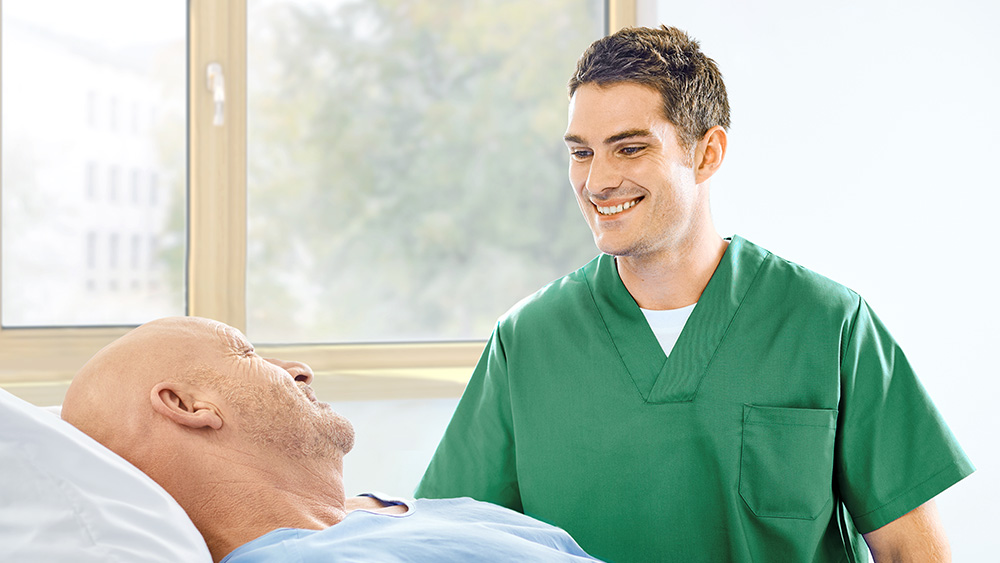 Nurse and patient in a hospital room both smiling