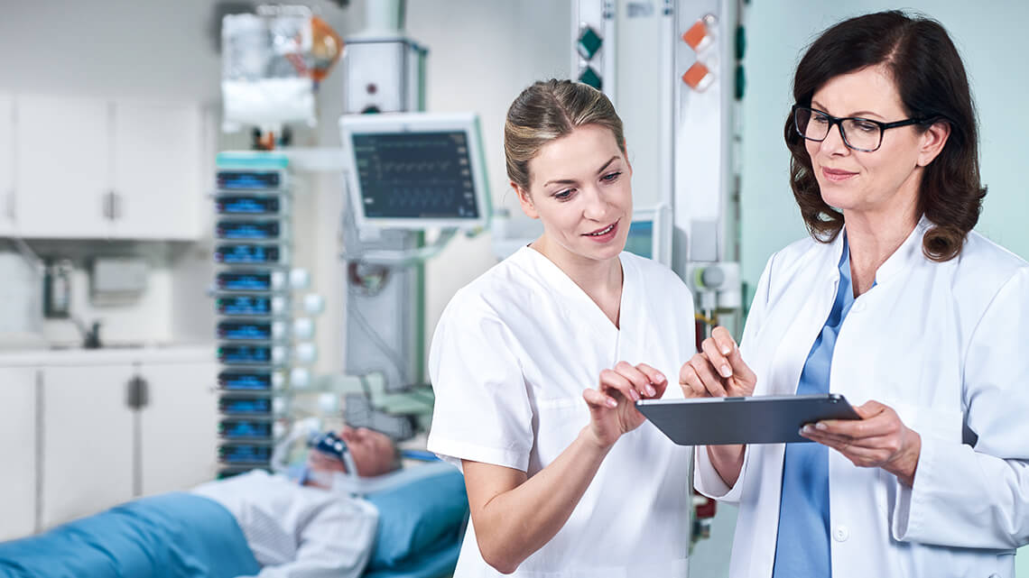 Two medical professionals use smart medication management via iPad