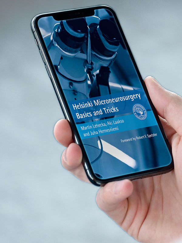 Hands holding a phone displaying the “Helsinki Microneurosurgery Basics and Tricks” guide