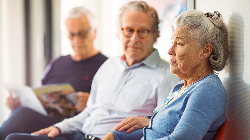 Elderly patients are waiting in the waiting room of a doctor's office.
